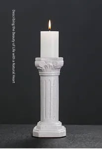 Detailed view of a ceramic Roman column candle holder with a lit pillar candle