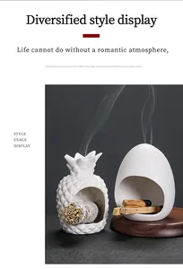 Witte keramische aromatherapie branders in ananas en eierschaal vorm op houten dienblad