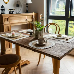 Sets de table en jute rustique avec bordures en dentelle sur une table en bois massif