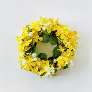 Dettaglio di una ghirlanda di fiori artificiali gialli e bianchi per anelli di candela