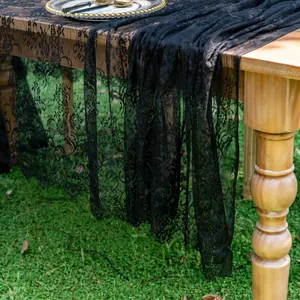 Detail view of premium black floral lace table runner draped over an elegant wooden table.