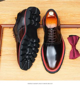 Détail de chaussures habillées brunes pour hommes avec semelle à crampons rouge et noir