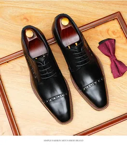 Vista superior de zapatos Oxford de cuero negro con remaches y una pajarita formal