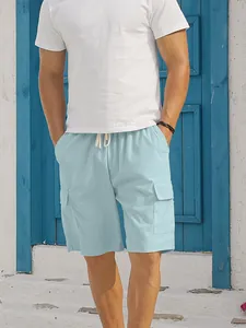 Detail of light blue corduroy cargo shorts with drawstring waist and functional side pockets.