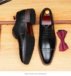 Primer plano detallado de zapatos Oxford de cuero negro con remaches decorativos en la puntera