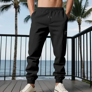 Close-up view of black men's casual cargo joggers featuring drawstring and ribbed cuffs.