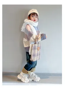Stylish little girl wearing white breathable mesh sneakers in a cozy autumn outfit
