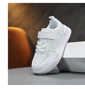 Side view of white kids sneaker with velcro strap and breathable leather upper detail