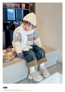 Little girl wearing beige chunky dad sneakers in a cozy indoor lifestyle setting.