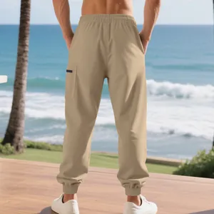 Back view detail of khaki heavyweight cargo joggers with side pocket in beach setting