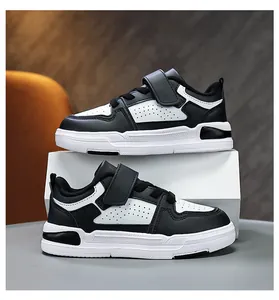Detailed side view of black and white children sneakers with velcro straps