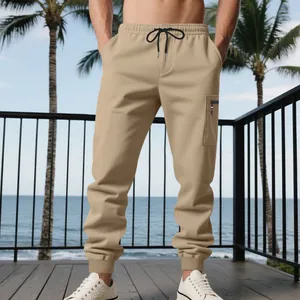 Detail view of khaki heavy-duty joggers featuring side zipper pocket and cuffed ankles.