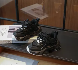 Detailed side view of stylish black chunky sneakers for girls featuring breathable mesh panels.