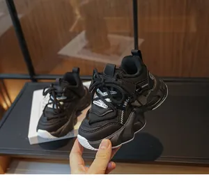 Detailed close-up view of black breathable mesh chunky sneakers for girls being held