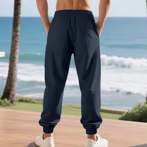 Rear view detail showing navy blue heavy men's sports cargo sweatpants with cuffed hem.