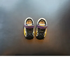 Draufsicht auf Lauflernschuhe für Kleinkinder mit gelb-violettem Farbblockdesign.