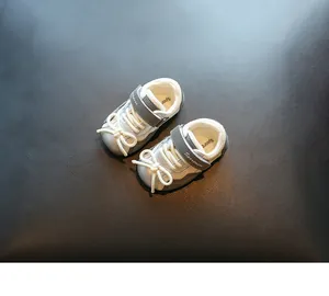 Detailansicht grauer Lauflernschuhe für Babys mit weichen Sohlen und Klettverschluss.