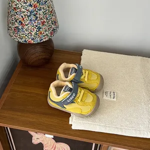 Primer plano de zapatos de invierno amarillos para bebés con forro polar cálido