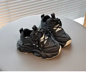 Detailed close-up view of black children's breathable chunky sneakers on a gray stand