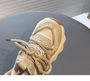 Detail of girl's breathable mesh chunky sneaker with cream "fashion" printed laces