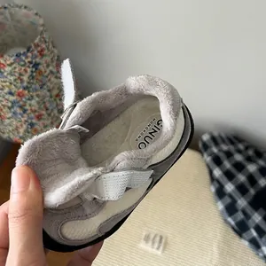 Primer plano de zapatilla de invierno para bebé con forro de piel gris y velcro