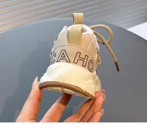Close-up detail of girls' beige chunky sneaker heel with CAHO text and textured sole