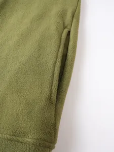 Dettaglio ravvicinato del tessuto in pile verde oliva e della tasca del pullover da uomo.
