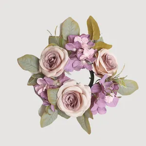 Vista detallada de una corona de flores artificiales con rosas y hortensias lila