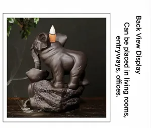 Back view of purple clay elephant backflow incense burner with smoke on wood base