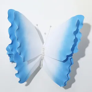 Dettaglio ravvicinato di una grande farfalla decorativa in schiuma sfumata blu e bianca.