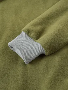 Dettaglio ravvicinato di felpa in pile verde oliva con trama del polsino elastico a coste grigio