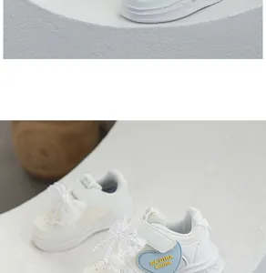 Detail view of girl's white sneakers with lace bows and heart-shaped accents.