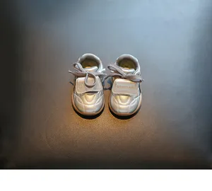 Detailweergave van zilveren baby-loopschoenen met zachte zool en klittenband