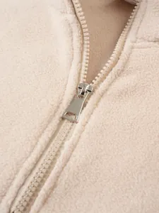 Primo piano dettagliato della cerniera in metallo e del morbido tessuto in pile di questo pullover