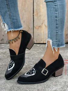 Détail de chaussures brodées noires à talons épais avec mesure de 5,5 cm de haut.