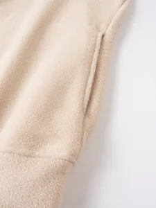 Dettaglio ravvicinato del morbido pile beige con particolare della tasca laterale maschile