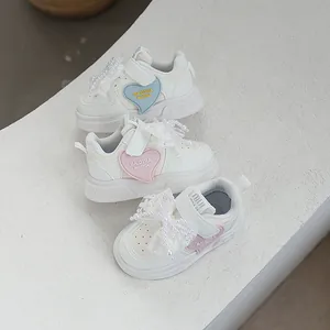 Stylish girls' white sneakers featuring heart patches and pearl lace bows, spring 2025