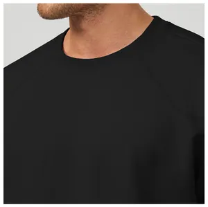 Gros plan détaillé d'un sweat-shirt noir à col rond pour homme avec manches raglan.