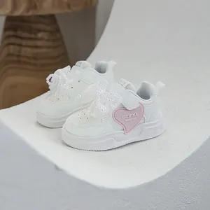 White girl's sneakers featuring a pink heart and elegant lace bow with pearl decorations