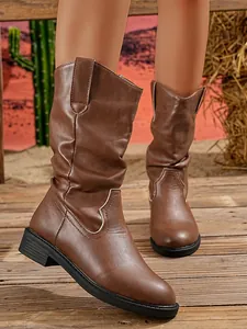 Detailed view of brown slouchy Western mid-calf boots with V-cut and block heel