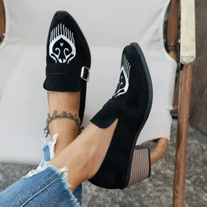 Mocassins noirs élégants à bout pointu, talon bloc et broderie blanche délicate.