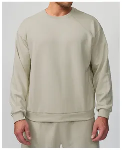 Gros plan d'un sweat-shirt beige à col rond pour homme, idéal pour le sport et les loisirs.