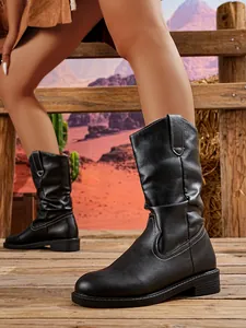 Detailed view of black mid-calf western boots with contrast stitching and block heel