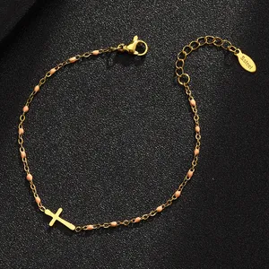 Detailansicht eines goldenen Edelstahlarmbandes mit Kreuz und rosa Emailleperlen