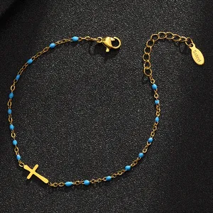 Detailansicht eines Edelstahlarmbands mit blauen Emaille-Perlen und Goldkreuz.
