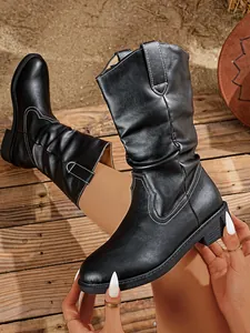 Detail of black Western mid-calf boots with contrast stitching and slouchy shaft design