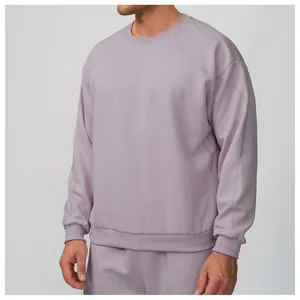 Détail d'un sweat à col rond lavande pour homme avec manches raglan confortables