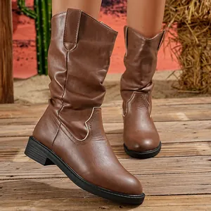 Stylish brown mid-calf western boots with V-cut and block heel on rustic wooden deck