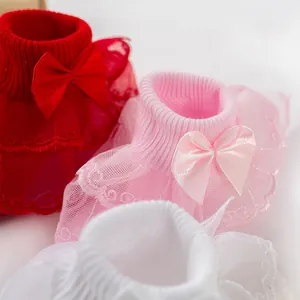 Détail de chaussettes pour bébé fille avec bordure en dentelle double et nœuds fins