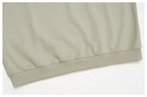 Vue détaillée de l'ourlet côtelé et de la texture du tissu d'un sweat-shirt vert clair pour hommes.